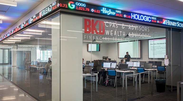 An economic analysis for investors class at the Glass Hall trading lab on campus.