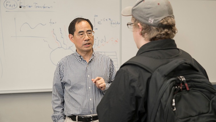 Math professor Dr. Xingping Sun talks to a student after class.