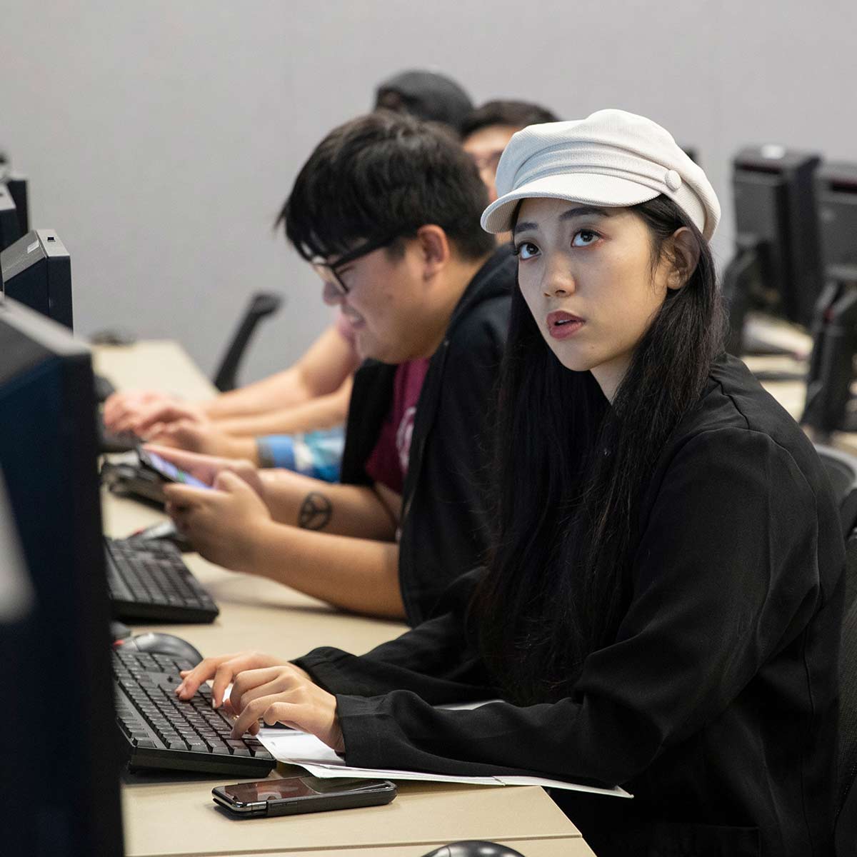 A student in a data analysis class looking focused while at her computer station.