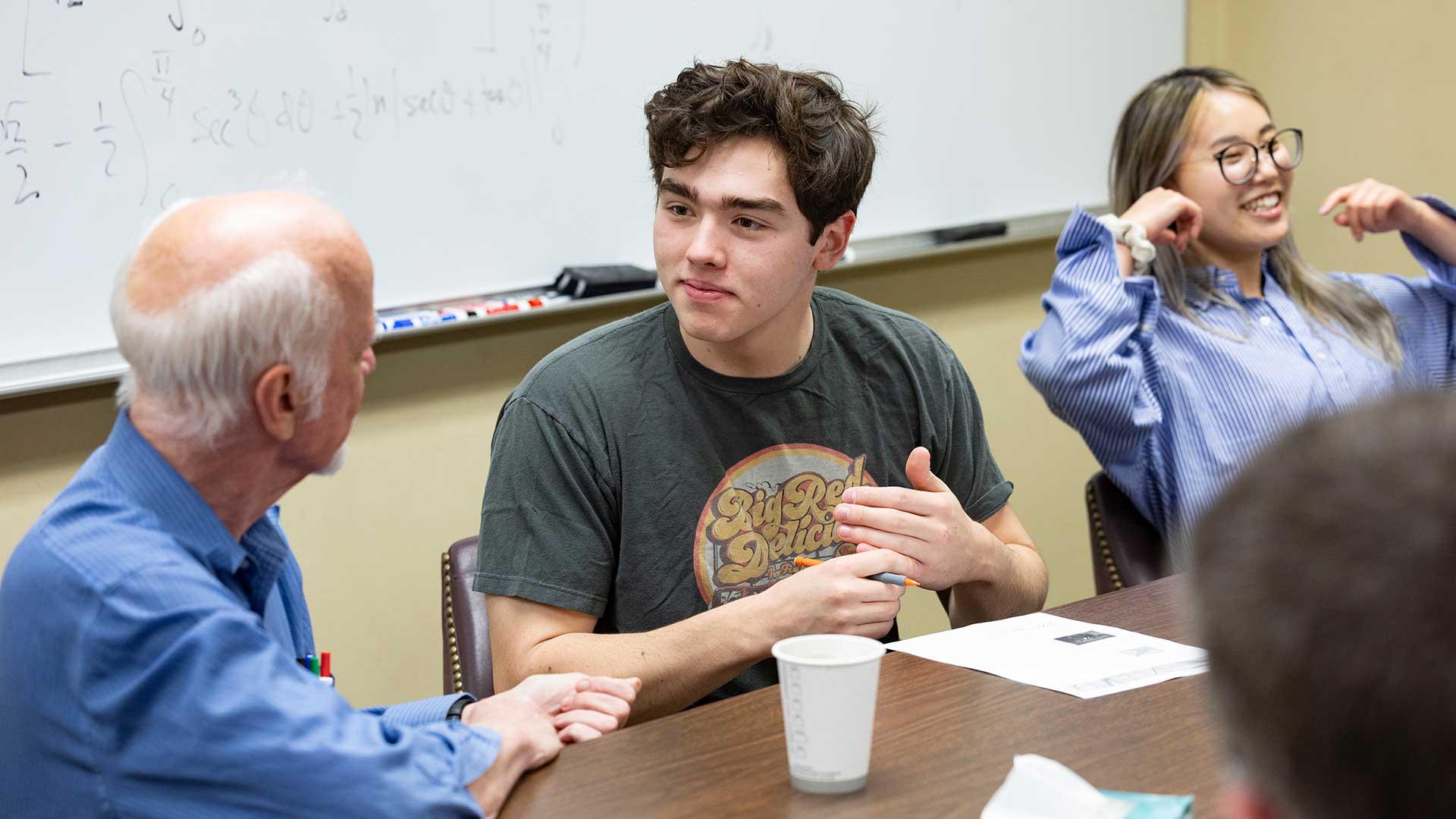 A professor and student have a conversation during a math problem-solving group meeting.